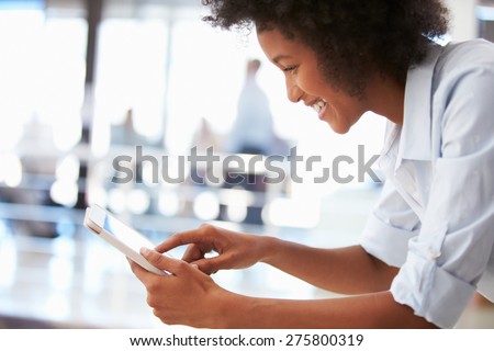 Portrait of smiling woman in office with tablet