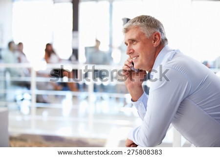 Portrait of middle aged man in office using smart phone,phone