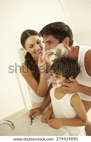 Mother And Son Watching Father Wet Shaving With Razor