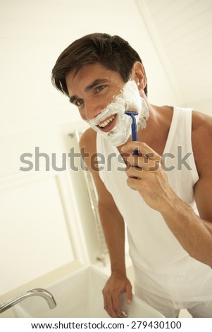 Young Man Wet Shaving With Razor