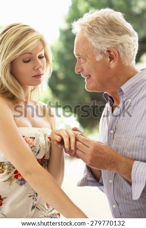 Older Man Proposing To Younger Woman