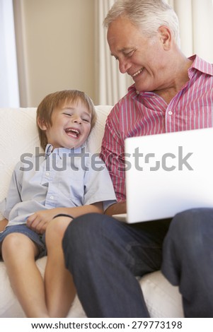 Grandfather And Grandson Using Laptop At Home