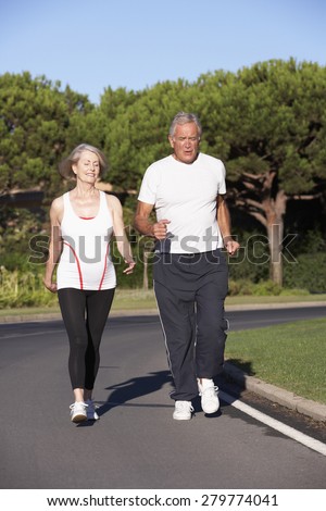 Senior Couple Running On Road