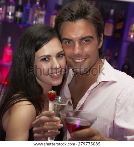 Young Couple Enjoying Drinks In Bar