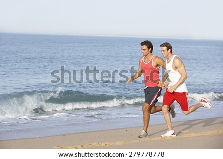 Two Young Men Jogging Along Beach