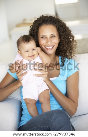 Young Mother On Sofa At Home