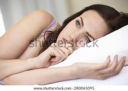 Worried Looking Young Woman On Bed