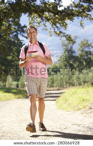 Middle Aged Man Hiking Through Countryside