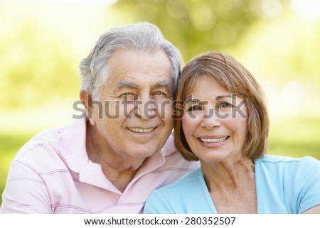 Senior Hispanic Couple Relaxing In Park