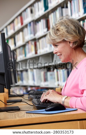 Senior woman working on computer in library