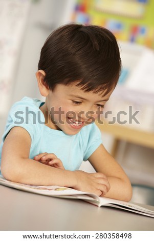 Elementary Age Schoolgirl Reading Book In Class