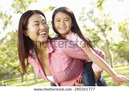 Portrait Asian mother and daughter playing in park
