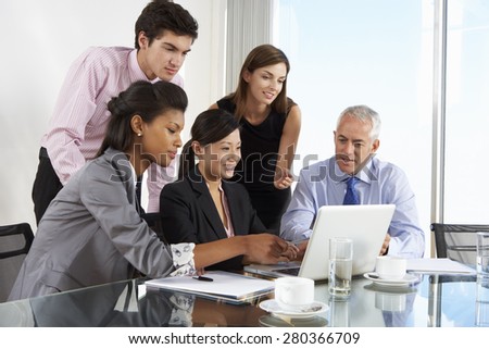 Group Of Business People Having Meeting Around Laptop At Glass Table