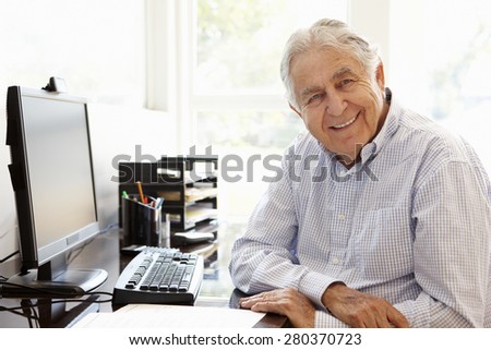 Senior Hispanic man working on computer at home