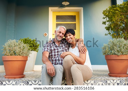 Mature Couple Sitting On Steps Outside House
