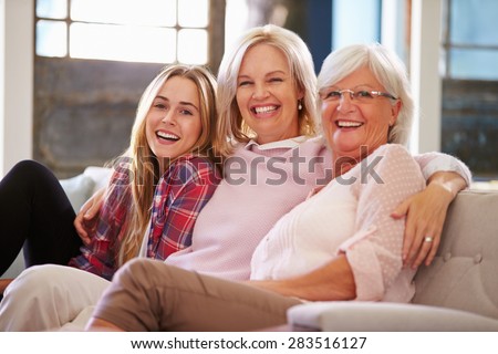 Grandmother With Mother And Adult Daughter Relaxing On Sofa