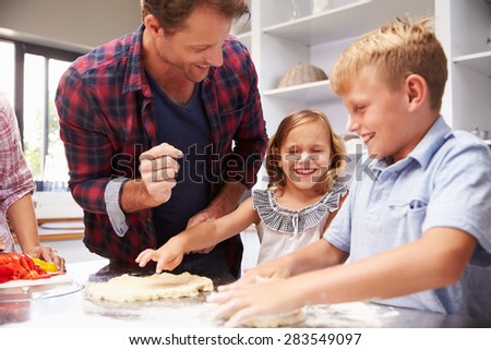 Father making pizza with kids