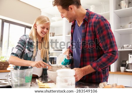 Father and daughter making a cake together