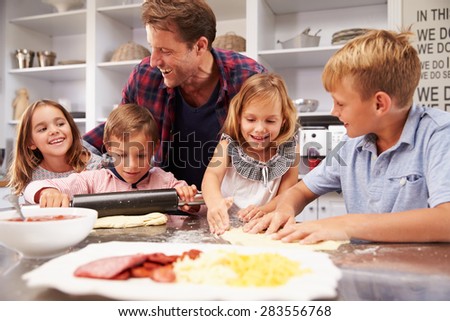 Father making pizza with his kids