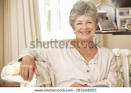 Retired Senior Woman Sitting On Sofa At Home