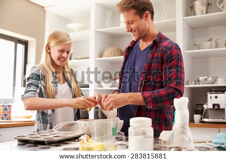 Father and daughter making a cake together