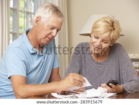 Mature Couple Checking Finances And Going Through Bills Together