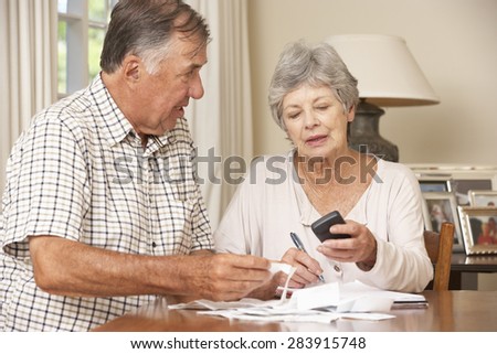 Senior Couple Checking Finances And Going Through Bills Together