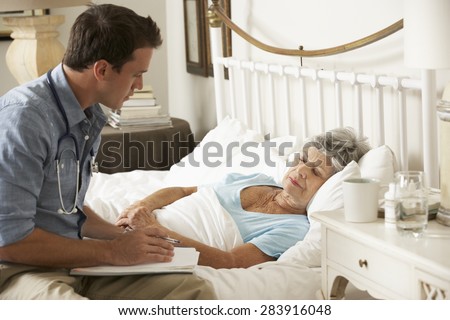 Doctor Talking With Senior Female Patient In Bed At Home