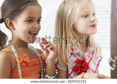 Two Young Girls Dressing Up And Putting On Make Up Together