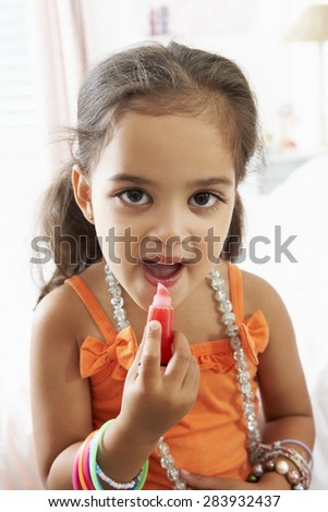 Young Girl Dressing Up And Putting On Make Up