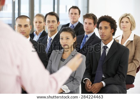 Group Of Business People Listening To Speaker Giving Presentation
