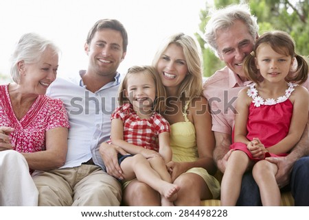 Multi Generation Family Sitting On Garden Seat