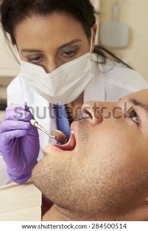 Man Having Check Up At Dentists Surgery