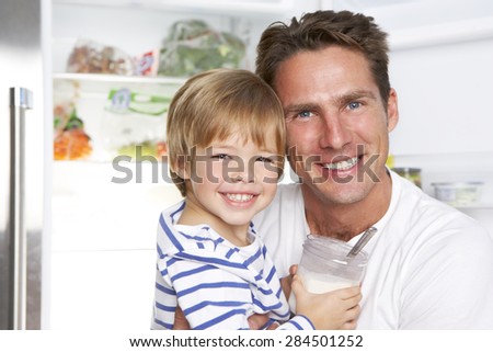 Father And Son Getting Snack From The Fridge