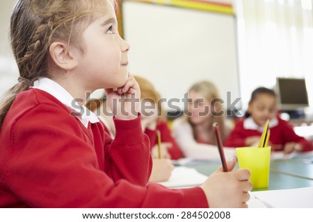 Female Elementary Pupil Working At Desk
