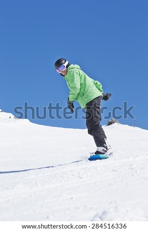 Man Snowboarding On Ski Holiday In Mountains