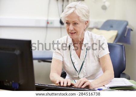 Female Consultant Working At Desk Using Digital Tablet