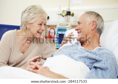 Senior Female Visiting Husband In Hospital Bed