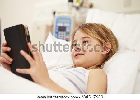 Young Female Patient Using Digital Tablet In Hospital Bed