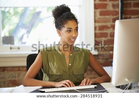 Woman Working At Computer In Contemporary Office