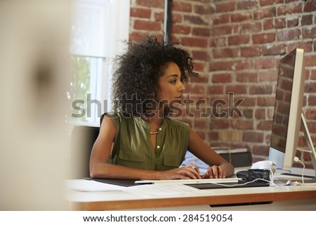 Woman Working At Computer In Contemporary Office