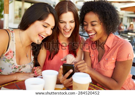 Three Female Friends Reading Text Message In Cafx81_