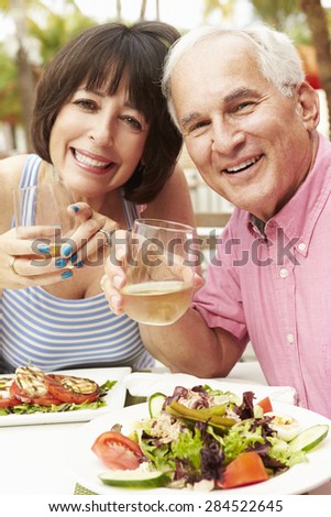 Senior Couple Enjoying Meal In Outdoor Restaurant Together