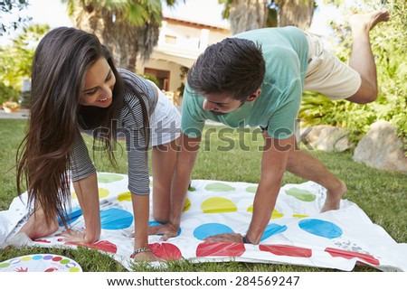 Young Couple Playing Balancing Game In Garden
