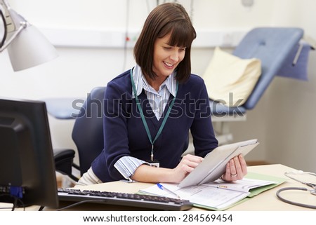 Female Consultant Using Digital Tablet At Desk In Office