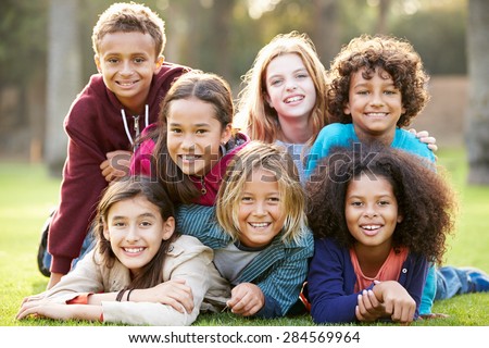 Group Of Children Lying On Grass Together In Park