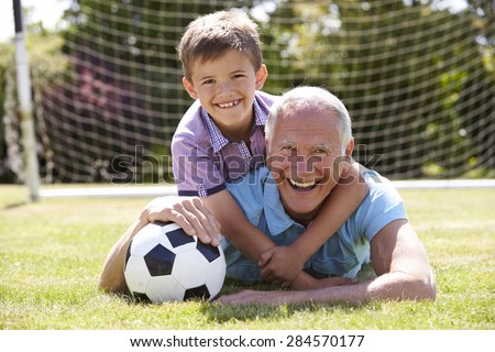 Portrait Of Grandfather And Grandson With Football