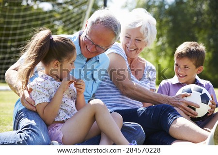 Grandparents And Grandchildren Playing Football In Garden