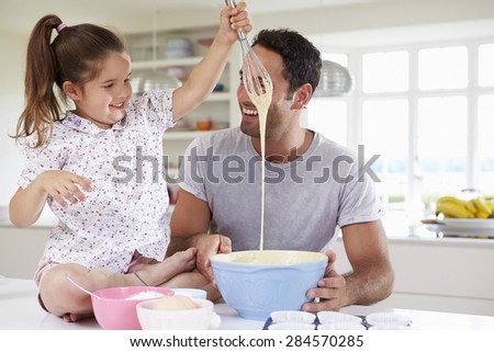 Father And Daughter Baking Cake In Kitchen