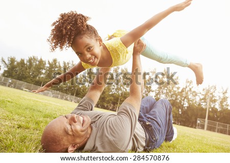 Grandfather Playing Game With Granddaughter In Park